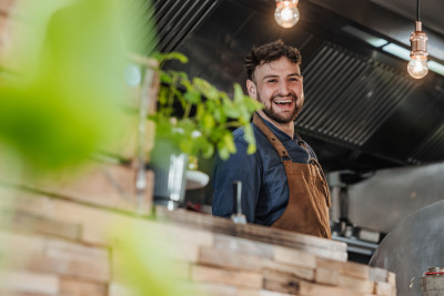 Lachender Koch von Dekhalu hinter einer Theke