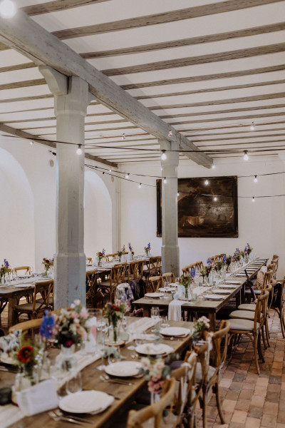 Große gedeckte Tafeln für eine Hochzeit in einer großen Location