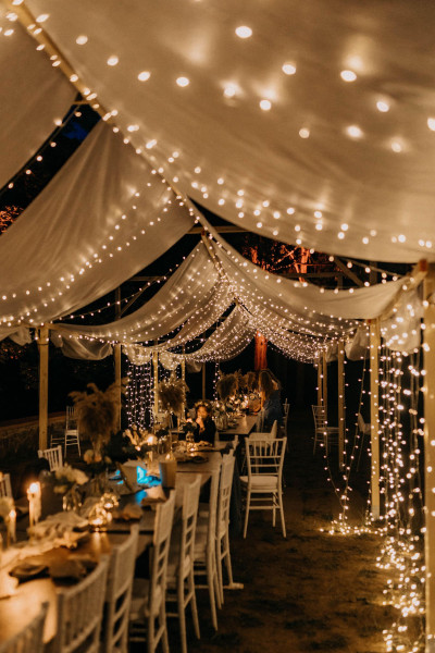 Mit Lichterketten ausgeschmücktes Zelt für eine romantische Hochzeit bei Nacht