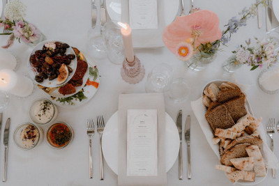 Ansicht auf einen romantisch gedeckten Tisch, Blumen, Kerzen und einige Vorspeisen sind zu sehen